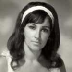 A young woman with long dark hair wearing a headband