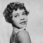 A young African American woman in a formal 3/4 view posed headshot photograph
